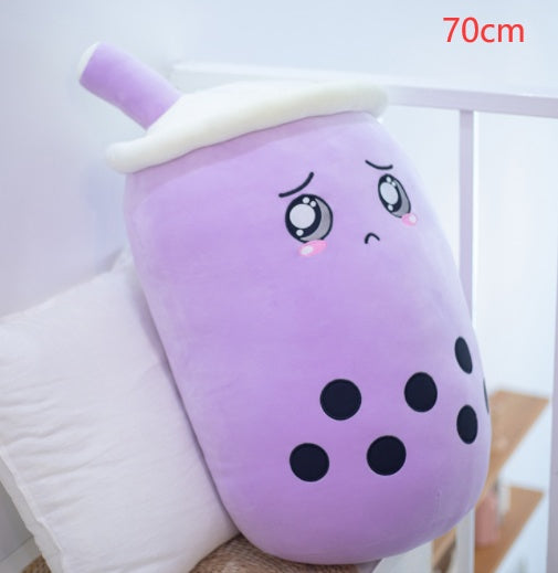 Purple plush boba drink pillow with white lid and straw, closed-eye face and black dots