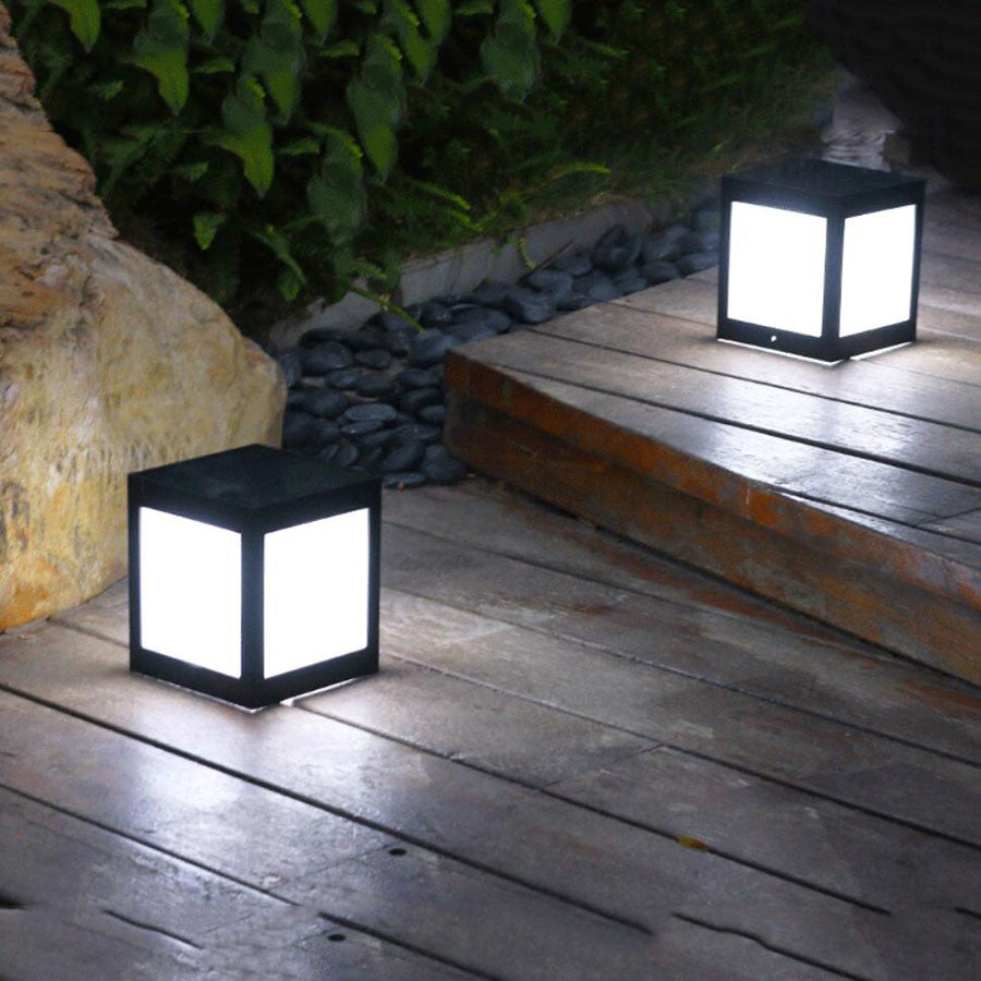 Pair of black solar lantern garden lights with frosted glass panels on outdoor deck