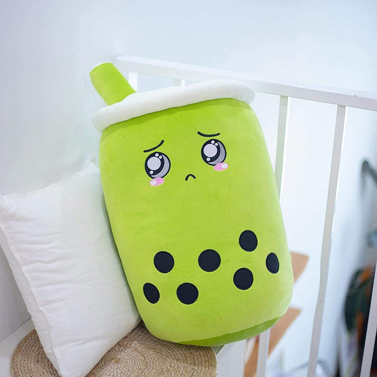 Green boba drink plush pillow with white lid and straw, cute face and black dot accents