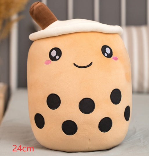 Light tan plush bubble tea cup pillow with brown straw, smiling face and black dot accents