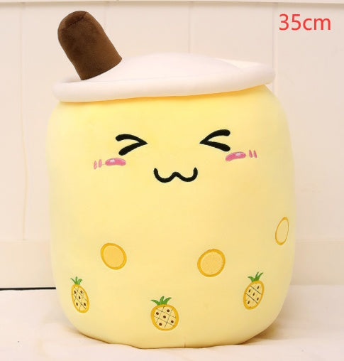 Yellow plush boba tea cup pillow with brown straw, pineapple graphics, and cute smile
