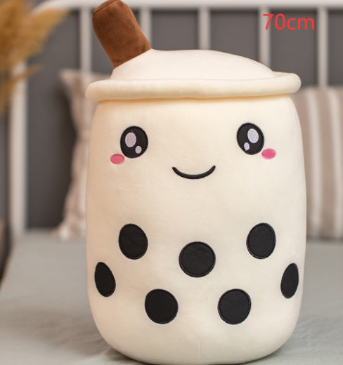 White plush boba tea cup pillow with brown straw, smiling mouth, and round spot details