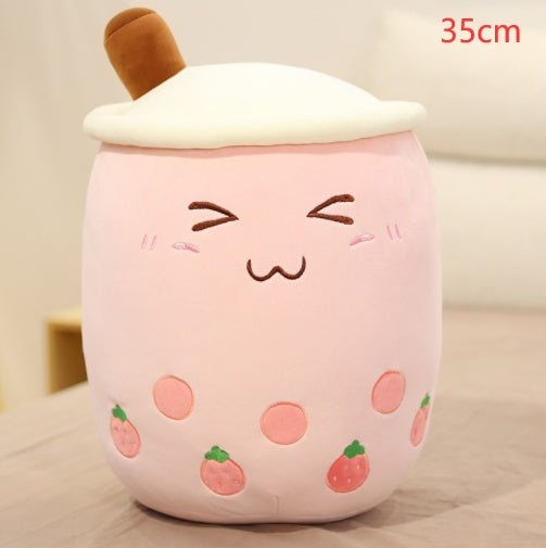 Light pink boba plush pillow cup with white lid and tan straw, strawberry pattern