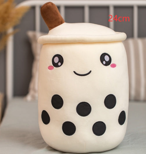 White plush boba tea cup pillow with brown straw and black eyes, dot spots