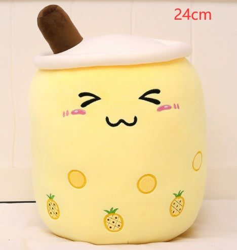 Yellow plush boba tea cup pillow with brown straw, pineapple prints, and smiling face
