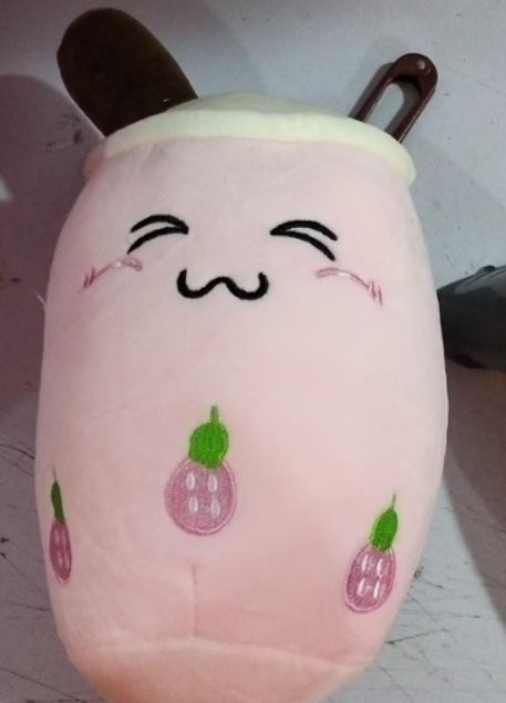 Pink plush drink toy with smiling face and strawberry icons, soft round cup shape
