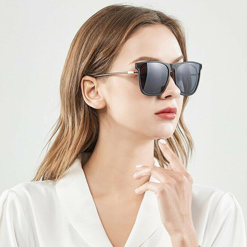 Woman wearing black clip-on sunglasses with dark tinted lenses over glasses