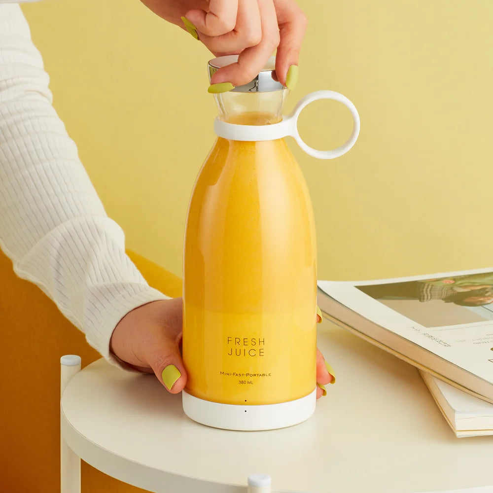 Portable mini fruit blender with yellow bottle, white base, and loop handle cup