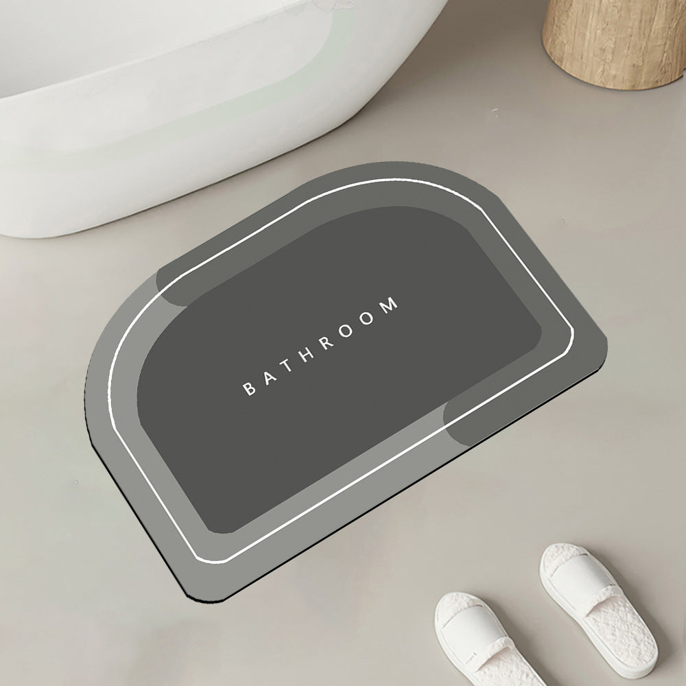 Quick-drying bathroom floor mat, gray with white border outline, angled view with inner ���BATHROOM���