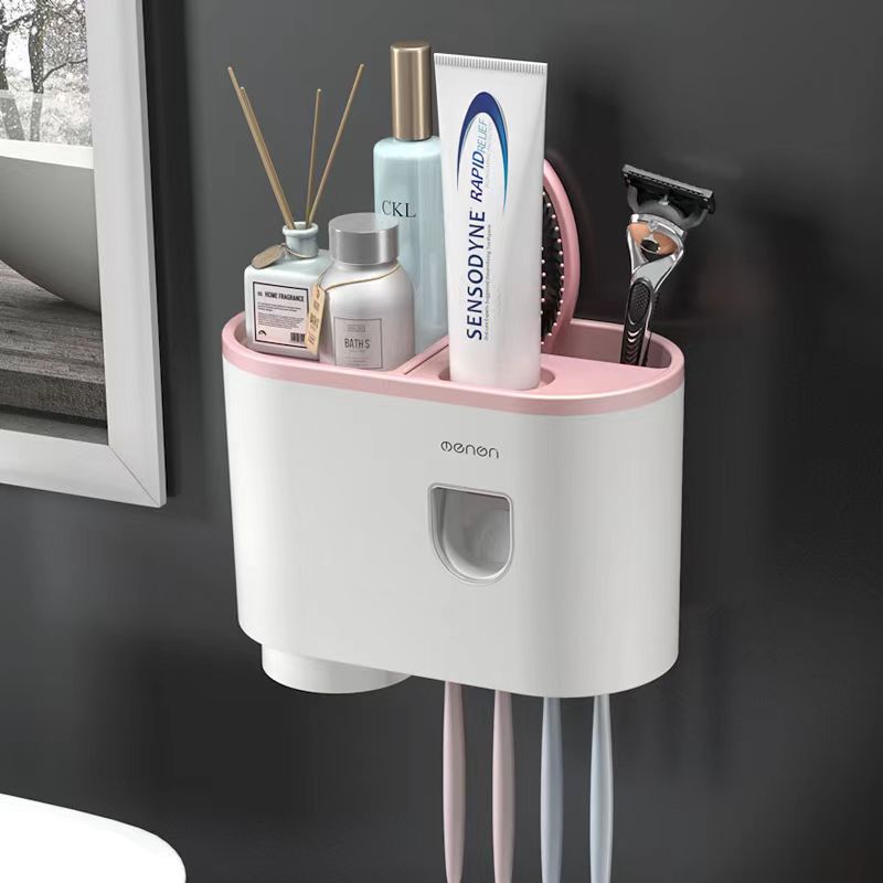 White wall toothbrush organizer with pink top tray and a drawer-style front opening