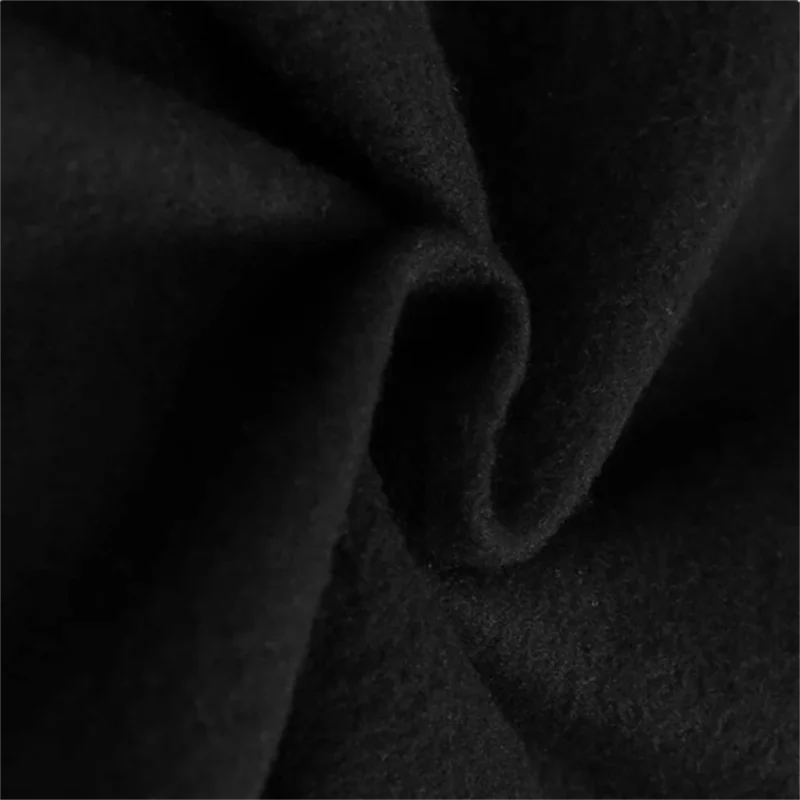 Black pullover hoodie fabric close-up with soft fleece texture and folds.