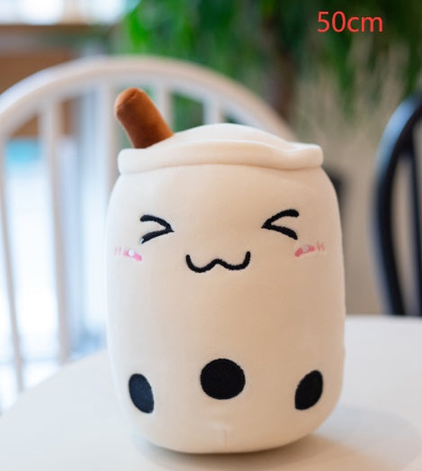 Cream plush bubble tea cup pillow with brown straw, closed eyes and black dot details