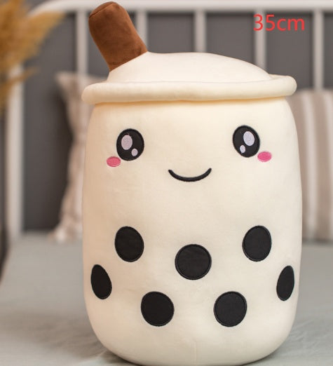 White plush bubble tea cup pillow with brown straw, smiling face and black dot accents