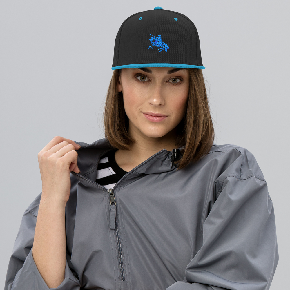 Snapback hat with black crown and teal brim, featuring a blue embroidered polo rider logo