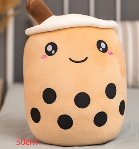 Tan plush bubble tea cup pillow with brown straw, white lid, smiling face and dark dot pattern