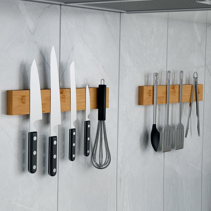 Wall-mounted knife organizer board holding several kitchen knives and utensils