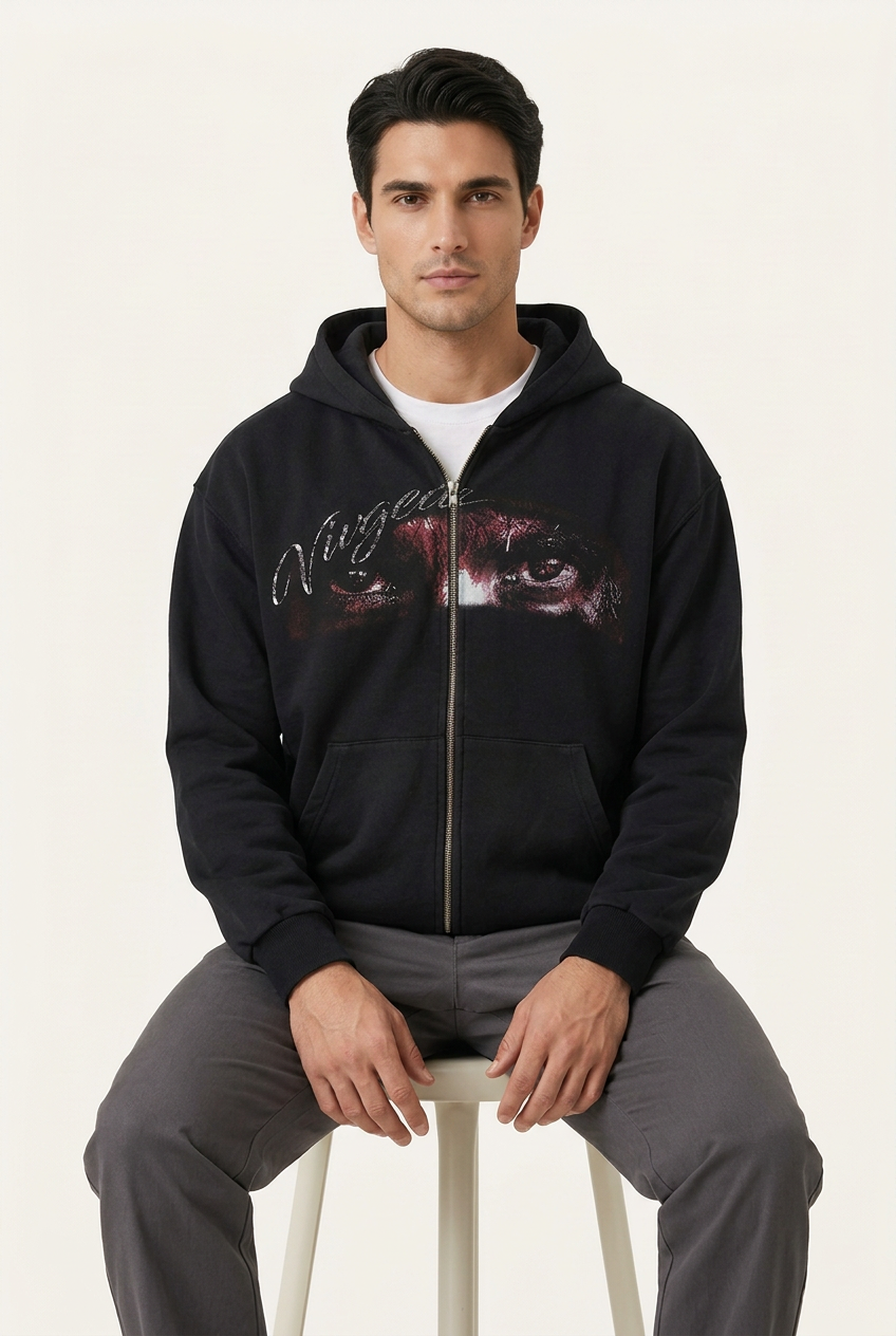 Same model seated wearing the black graphic hoodie
