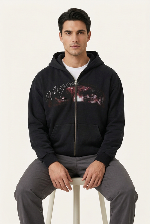 Same model seated wearing the black graphic hoodie